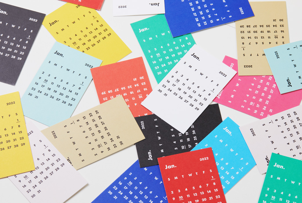 カラフルなミニマルカレンダーが机にランダムに置かれている