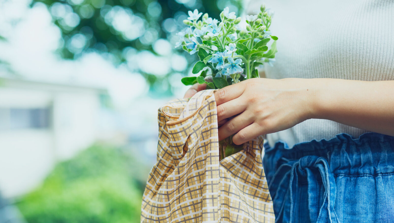 手拭いエコバッグハンカチにお花を入れ持っている
