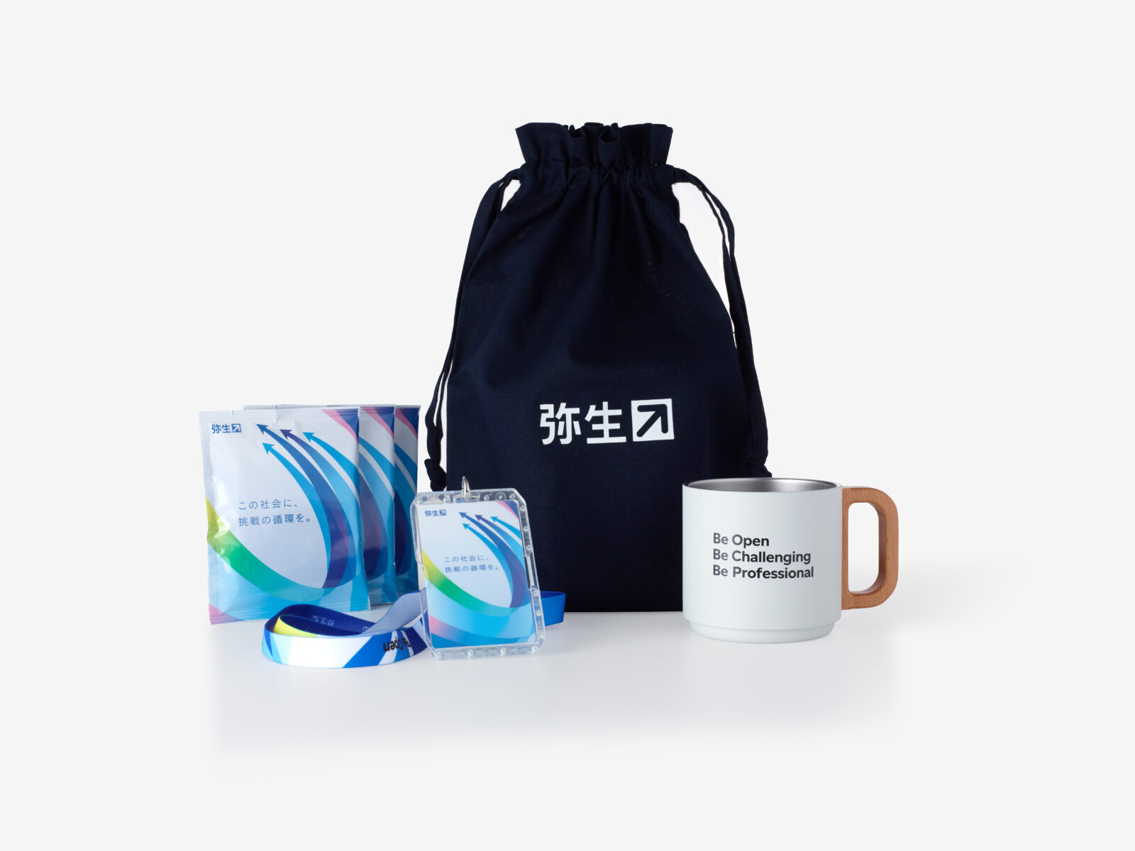 巾着に入っているギフトセット。中身のマグカップとドリップコーヒー、カードケース付きネックストラップが巾着と一緒に並んでいる。